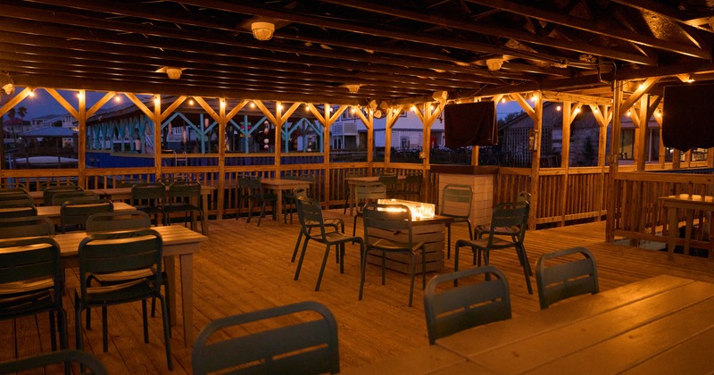 Exterior, outdoor patio with roof, dining area with wooden floors, chairs and tables