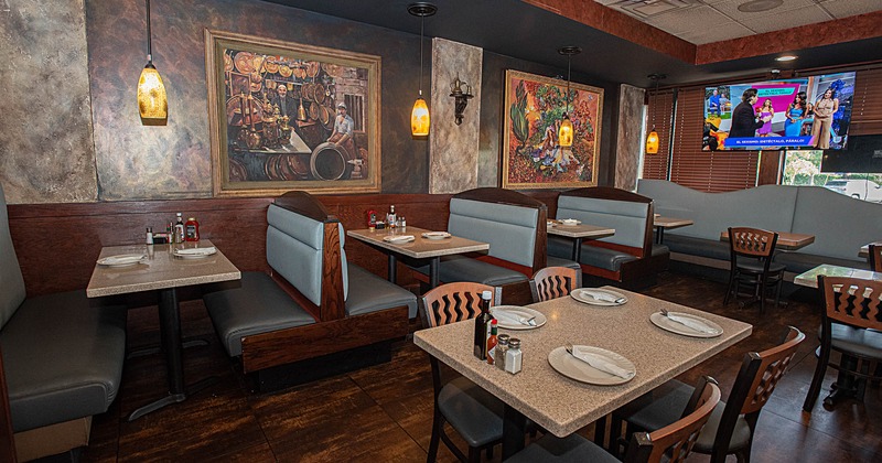 Interior, tables, chairs and sitting booths ready for guests, framed pictures on the walls