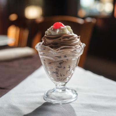 Chocolate Mousse topped with whipped cream and a cherry garnish.
