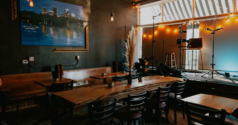 Tables and seating in front of a music stage with artwork on the wall