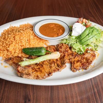 Carne Asada served with Mexican rice, charro beans and aguacate salad.