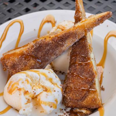 Deep Fried Cheesecake served with ice cream and a drizzle of caraamel sauce.