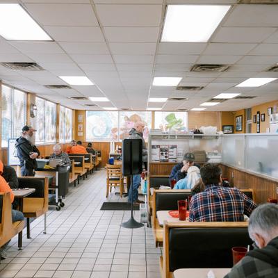 Interir with tiled flor, booth seating and a counter area.