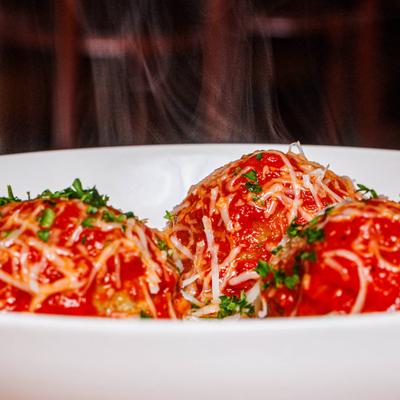 Meatballs with tomato sauce, Parmesan cheese, and chopped parsley.