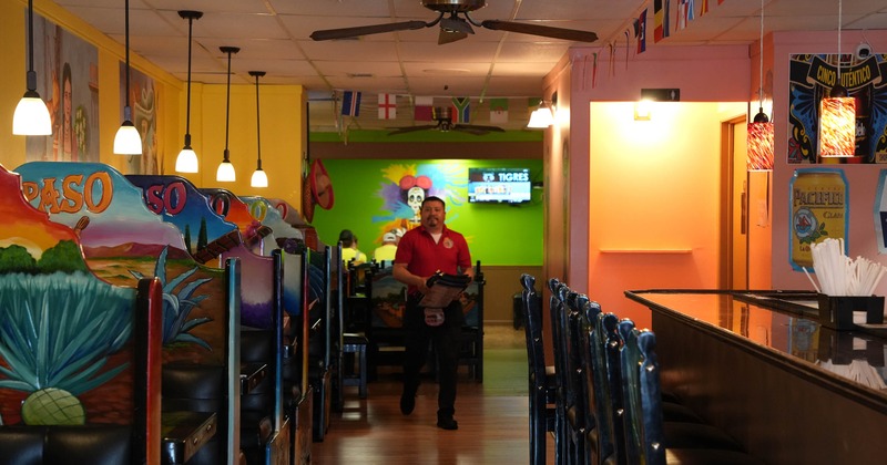 Interior, wide shot: bar on the left, booths on the right, staff in the center.
