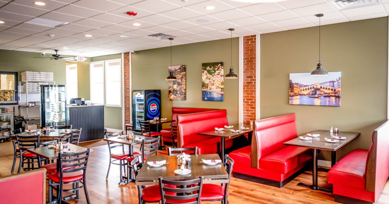 Interior of a casual dining restaurant with red booths, tables and decorations.