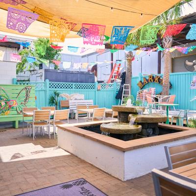 Outdoor patio with colorful banners and a central fountain.