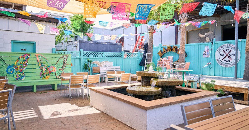 Outdoor patio with colorful banners and a central fountain