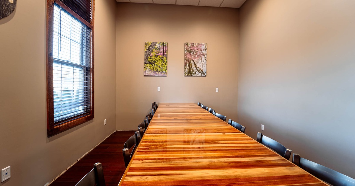 Interior, room with long wooden table and chairs, pictures on the wall