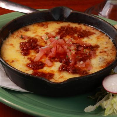 Melted Manchego and Jack cheese fondue with pork chorizo, close up