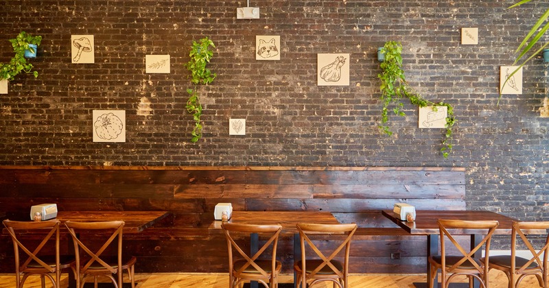 Interior, dining area, wooden banquette bench with tables, small graphics as decoration