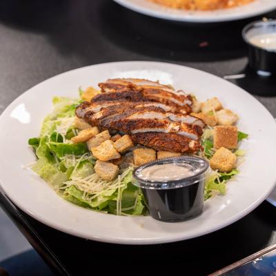 Grilled chicken salad with croutons and dressing.