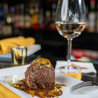 Dubai chocolate ball, glass of wine.