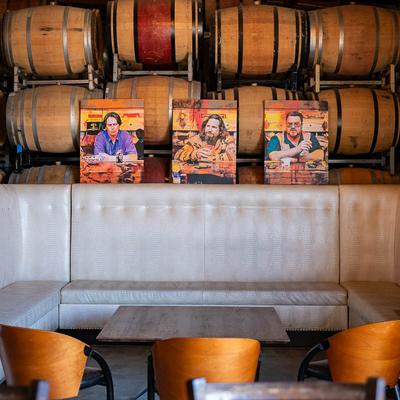 White booth against a wooden barrel backdrop with three colorful portraits of movie characters.