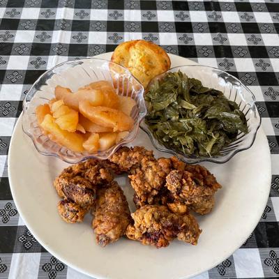 Fried livers with sides of fresh cut fruit, turnip greens, and cornbread.