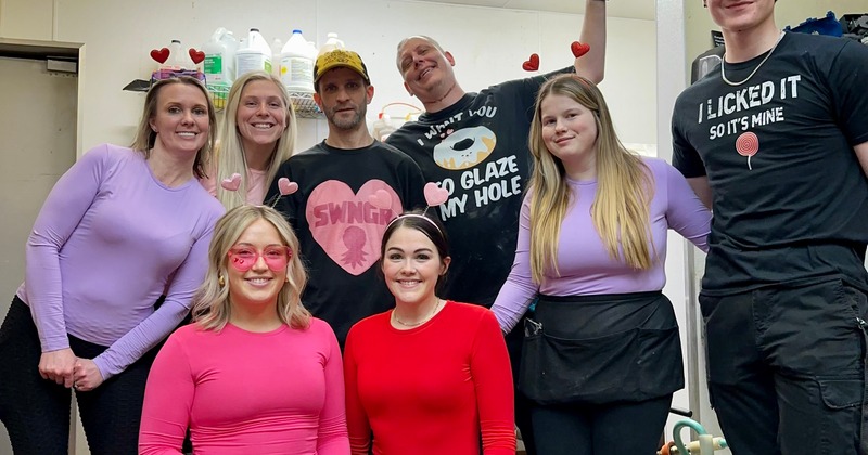 Eight smiling coworkers  pose together indoors