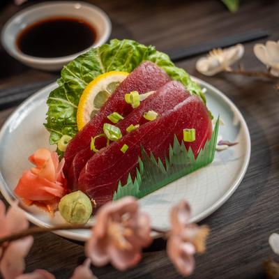 Tuna sashimi with pickled ginger, wasabi, and lemon slice.