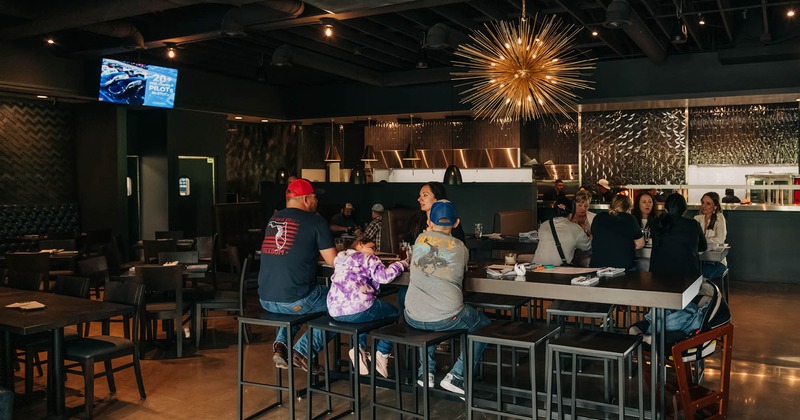 Interior, multiple seating areas, including high top tables with stools and standard dining tables