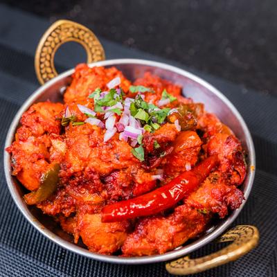 Chili Chicken garnished with diced onion and cilantro.