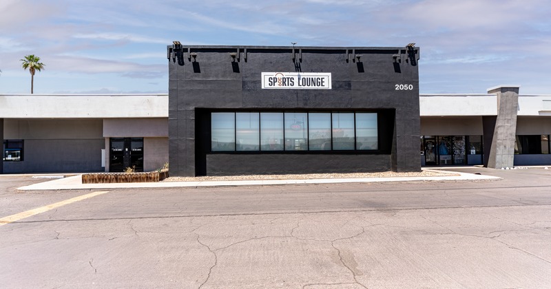 Exterior, front view to restaurant, entrance, sign above, parking lot in front