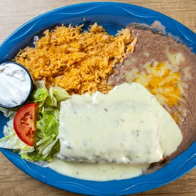 White chimichanga served with rice, beans, sour creme and fresh salad.