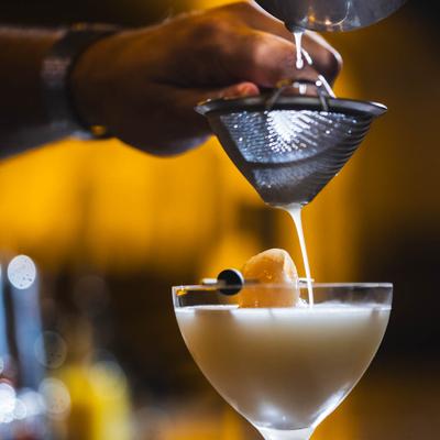 Bartender straining a Lychee Martini.