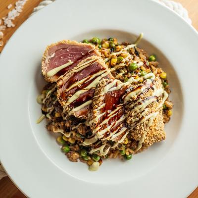 Seared sesame crusted tuna on a bed of fried rice.