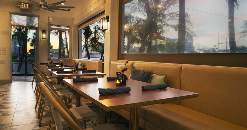 Modern interior - wooden tables, leather banquette seating and large windows.