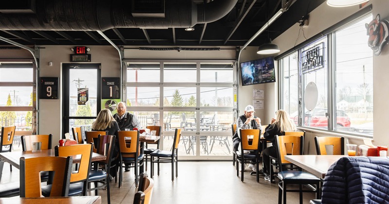 Interior, wide view, tables and chairs, guests enjoying their food and drinks