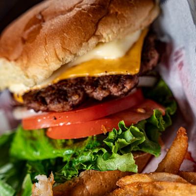 A close up of cheeseburger and fries.