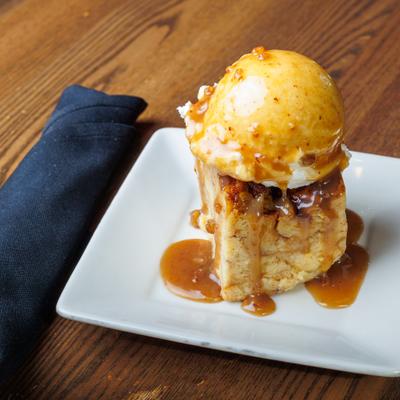 Bread pudding topped with ice cream.
