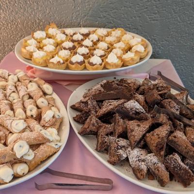 Three platters of various desserts served on the table.