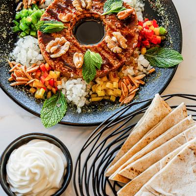 Kebbeh nayeh dish, served with pita and a creamy white spread.