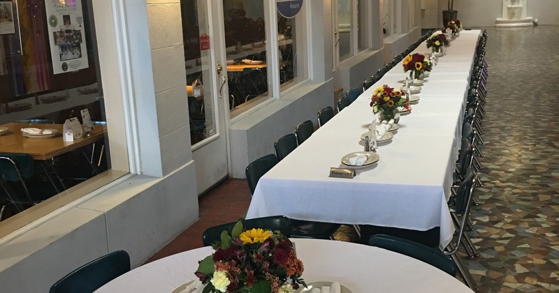 Private tables covered with white tablecloth, set with tableware and floral display