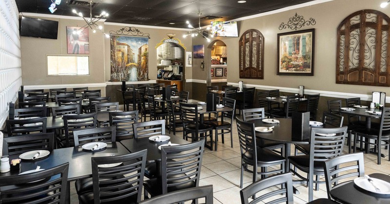 Interior seating area with tables, chairs and decorative art on the walls
