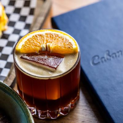 Reposado Carajillo cocktail garnished with a slice of orange.