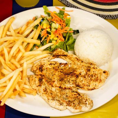 Grilled chicken breast served with white rice, fries, and salad.