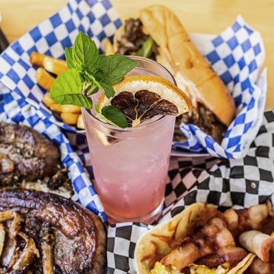 Thursday Eve cocktail surrounded by assorted food dishes.