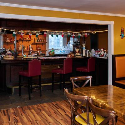 Restaurant bar area with red stools and holiday decorations.