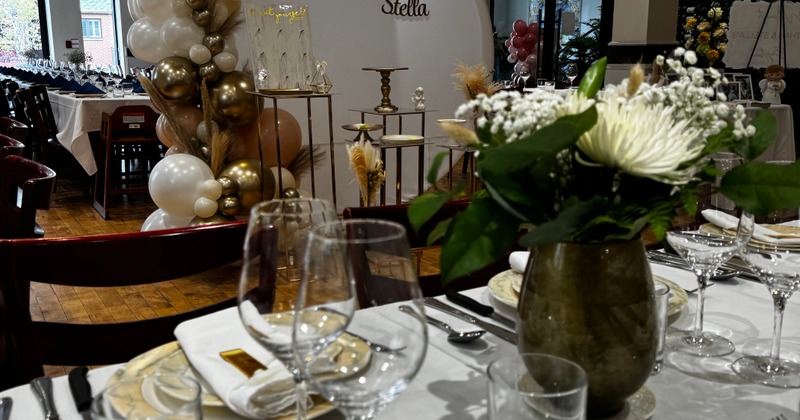 Interior featuring a decorated table with a floral centerpiece and a balloon arrangement