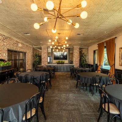 Banquette room with round tables and modern chandeliers.