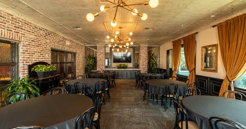 Banquette room with round tables and modern chandeliers