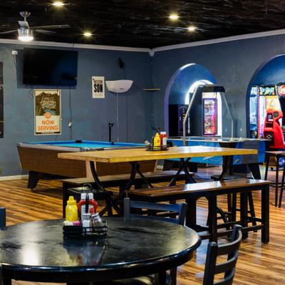 Interior with  aseating area, pool tables and arcade games.
