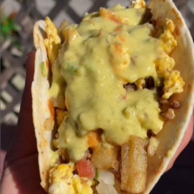 Hand holding a Breakfast Taco, close-up.