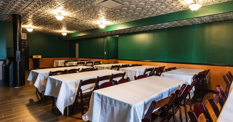 Interior, open space dining area, tables for six, green and orange painted walls