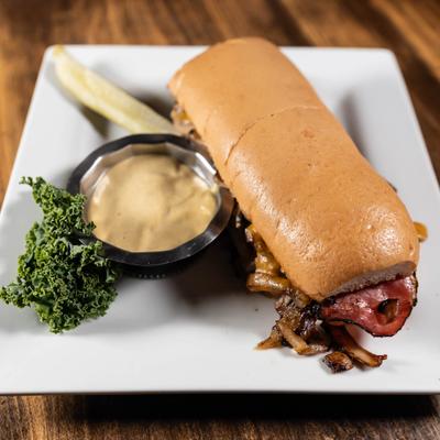 Sub Supreme, served on a plate with dip and a pickle.