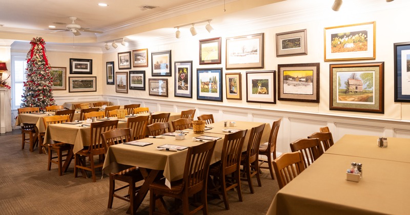 Cozy interior dining area with dining tables set for guests and a Christmas tree