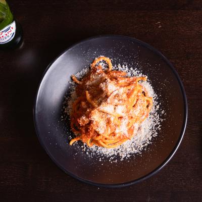 Bucatini pasta with tomato sauce and cheese.