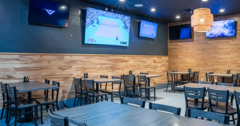 Interior, seating area, tables and chairs, TVs on the walls