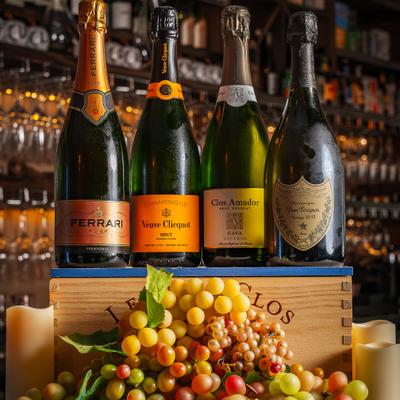 Sparkling wine bottles displayed above colorful grapes.